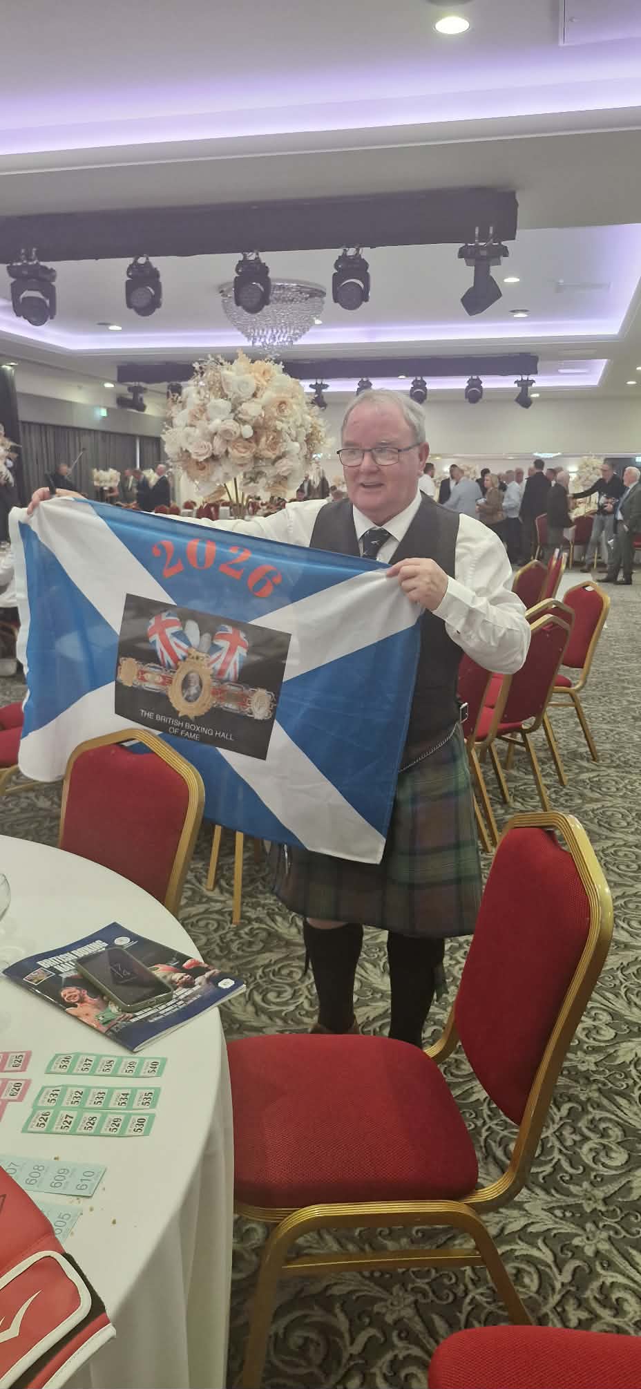 Jock McInnes MBE proudly displaying the Scottish Saltire flag at the Hall of Fame ceremony 2026
